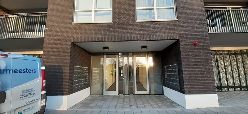 Deurmeesters-bus bij de entree van een appartementencomplex