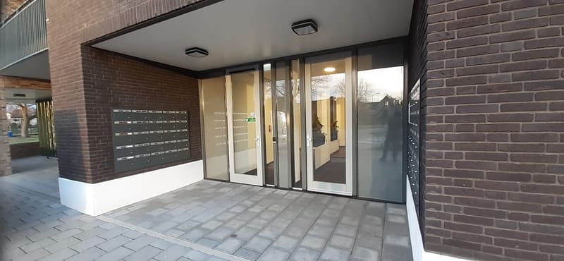 Moderne entree van een appartementencomplex met intercom en taglezer